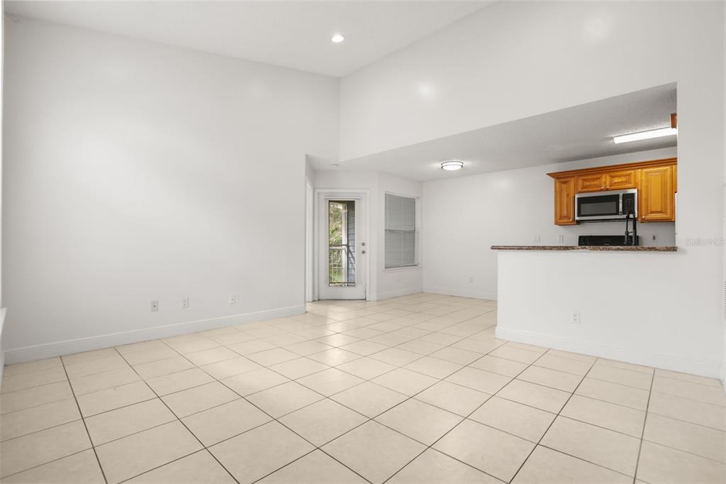 An open living area features tile flooring, a vaulted ceiling, and a large arched window — 2584 GRASSY POINT DRIVE UNIT 204, LAKE MARY, FL