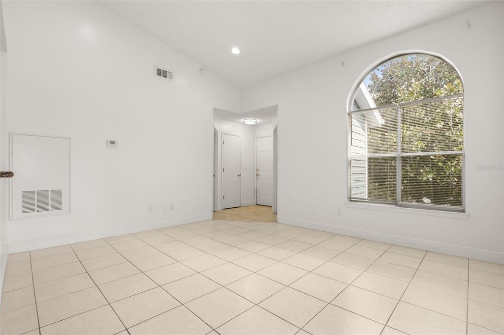 A living area with tile flooring, a vaulted ceiling, and an arched window — 2584 GRASSY POINT DRIVE UNIT 204, LAKE MARY, FL