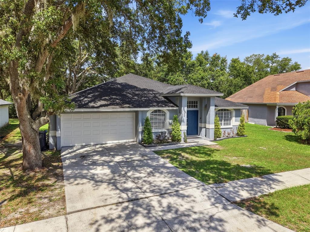 A single-story house with a gray exterior, blue double front doors, and a concrete driveway — 1328 GANGPLANK DRIVE, VALRICO, FL