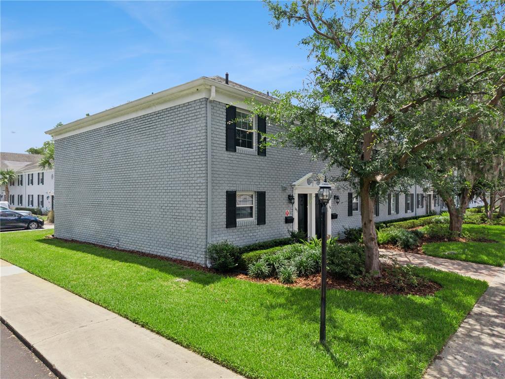 A two-story gray brick building with black shutters and a sidewalk in the foreground — 193 LEWFIELD CIRCLE, WINTER PARK, FL