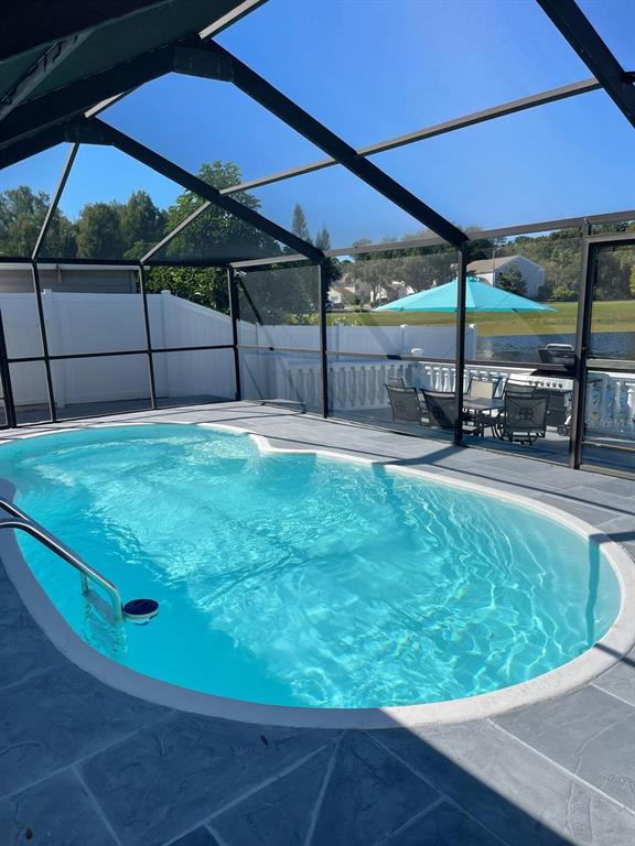 A screened-in swimming pool with a patio and a view of a lake — 6423 MONTEREY BOULEVARD, TAMPA, FL