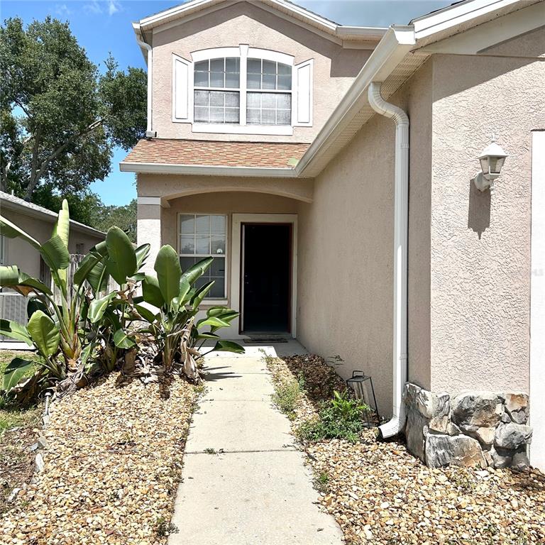 A light-colored single-story house with a garage and a large tree in the front yard — 504 MAPLE POINTE DRIVE, SEFFNER, FL