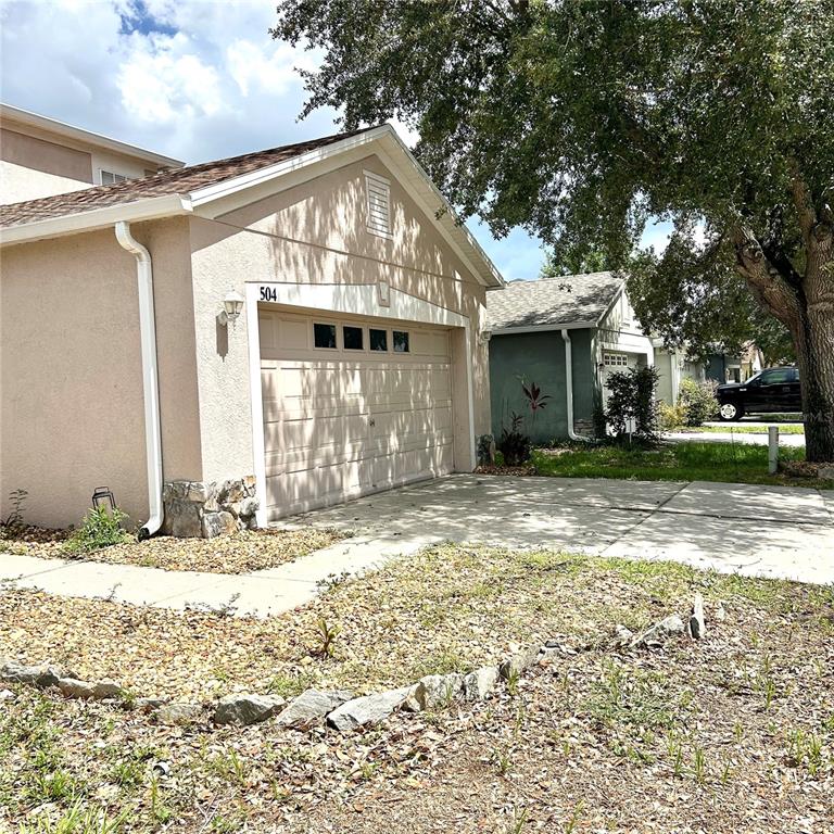 A two-story house with a concrete driveway and a large tree in the front yard — 504 MAPLE POINTE DRIVE, SEFFNER, FL