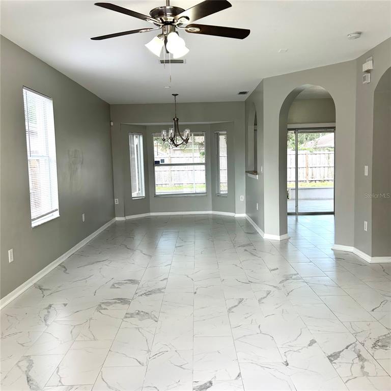 A dining area features light-colored tile flooring, a chandelier, and a pass-through window to the kitchen — 504 MAPLE POINTE DRIVE, SEFFNER, FL