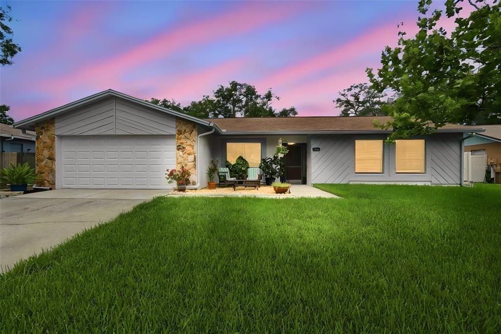 A single-story house with a gray exterior, stone accents, and a two-car garage — 3721 SAND PEBBLE DRIVE, VALRICO, FL