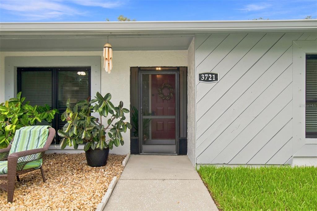 A single-story house with a light gray exterior, stone accents, and a concrete driveway — 3721 SAND PEBBLE DRIVE, VALRICO, FL