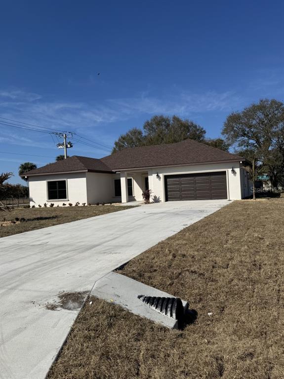 A single-story house with a white exterior, dark roof, and a concrete driveway — 2383 SW 2ND COURT, OKEECHOBEE, FL