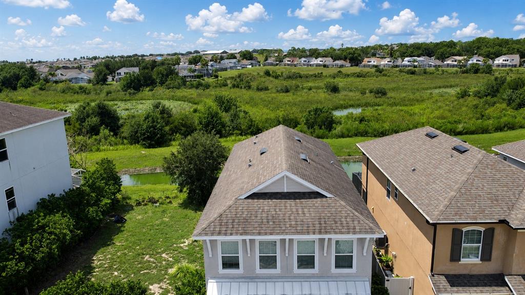 A two-story house with a beige exterior, a brown garage door, and a concrete driveway — 205 ABERDEEN STREET, DAVENPORT, FL