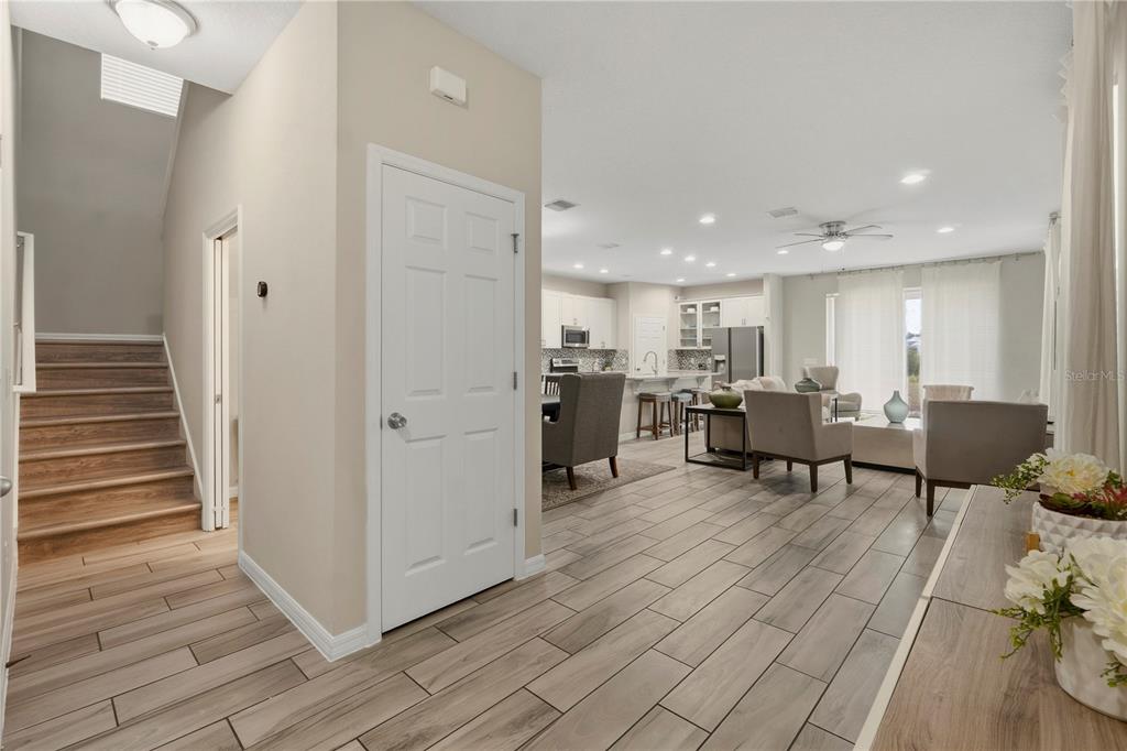 A view from a hallway looking into an open-concept living room and kitchen area — 205 ABERDEEN STREET, DAVENPORT, FL