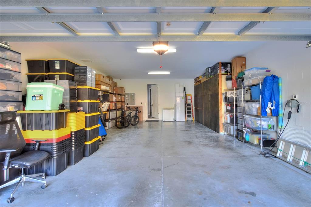 A kitchen features dark wood cabinets, granite countertops, a tiled backsplash, and stainless steel appliances — 232 MAGNETA LOOP, AUBURNDALE, FL