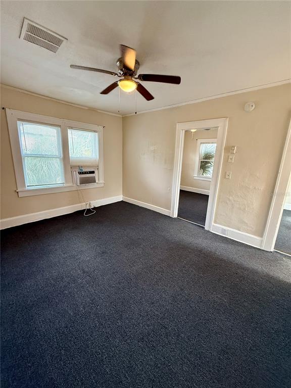 A room with dark carpeting, a ceiling fan, and a window unit air conditioner — 634 14TH STREET N UNIT 1/2, ST PETERSBURG, FL