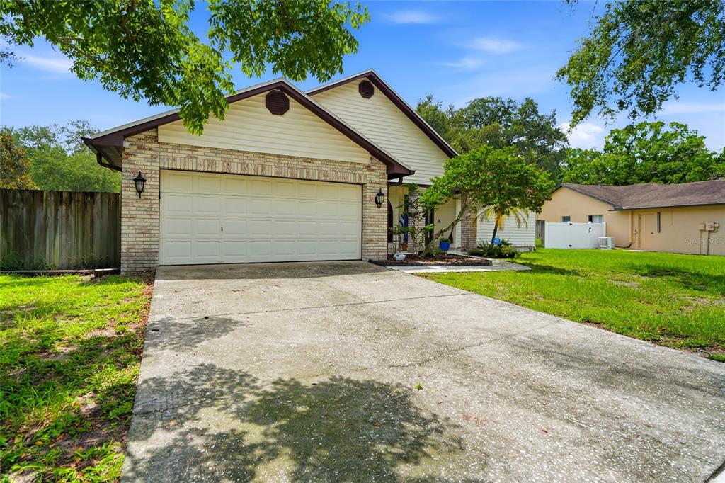A single-story house with a two-car garage, brick facade, and a concrete driveway — 1150 WINDSOR WAY, LUTZ, FL