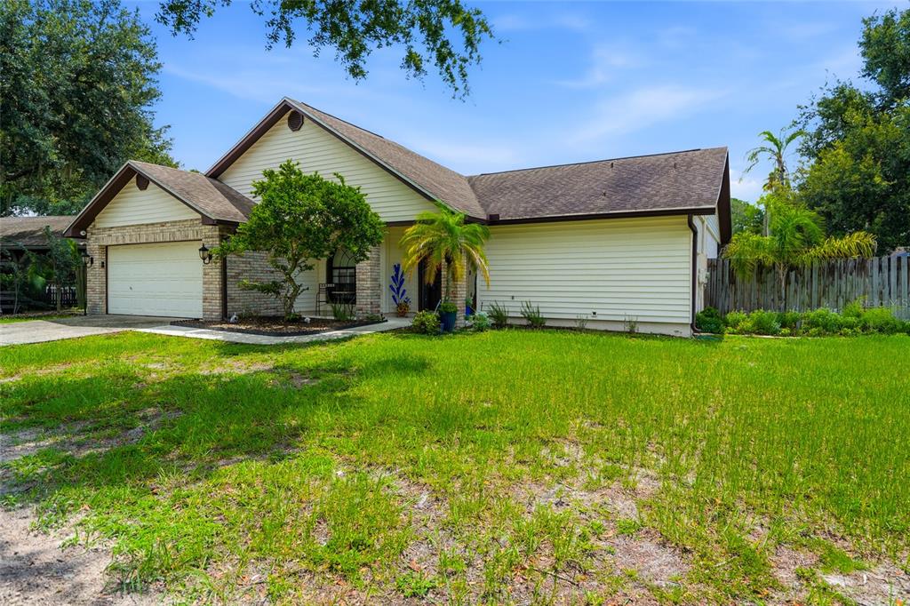 A single-story house with a beige siding exterior, a brick facade, and a two-car garage — 1150 WINDSOR WAY, LUTZ, FL