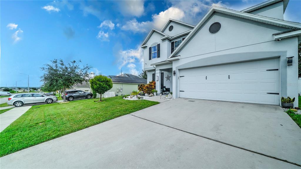 A two-story suburban house with a white exterior, a two-car garage, and a concrete driveway — 2015 BARSTOW LANE, DUNDEE, FL