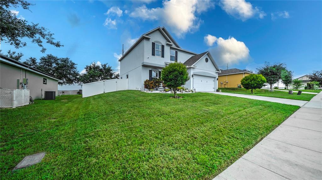 A two-story house with a white exterior, a two-car garage, and a grassy front yard — 2015 BARSTOW LANE, DUNDEE, FL
