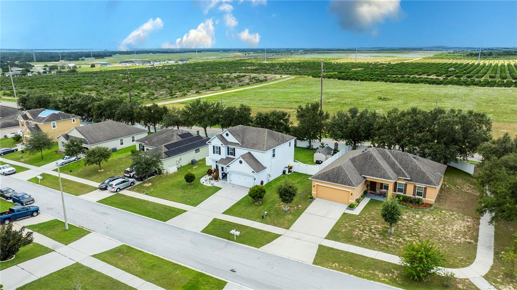 An aerial view shows several suburban houses with driveways and lawns bordering a large field — 2015 BARSTOW LANE, DUNDEE, FL