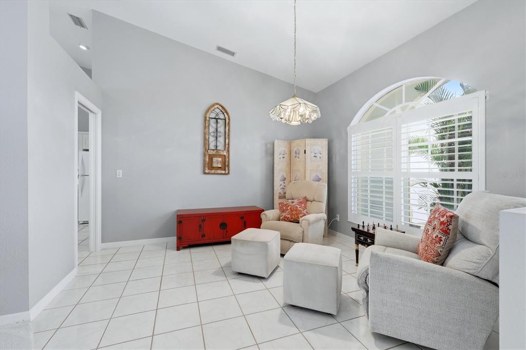 A bright entryway features white tile floors, double glass-paneled doors, and a small seating area — 1787 KILRUSS DRIVE, VENICE, FL