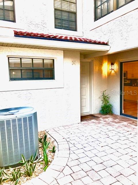 A black wrought iron gate stands within a stucco archway leading to a paved walkway — 8214 AMBROSE COVE WAY, ORLANDO, FL