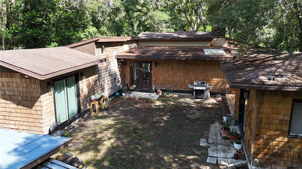 An aerial view of a cedar-shingled house with a central courtyard and multiple roof sections — 34146 UMBRELLA ROCK DRIVE, WEBSTER, FL