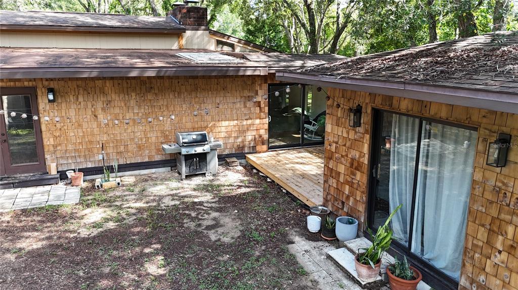 An exterior view of a house with cedar shake siding, a wooden deck, and sliding doors — 34146 UMBRELLA ROCK DRIVE, WEBSTER, FL