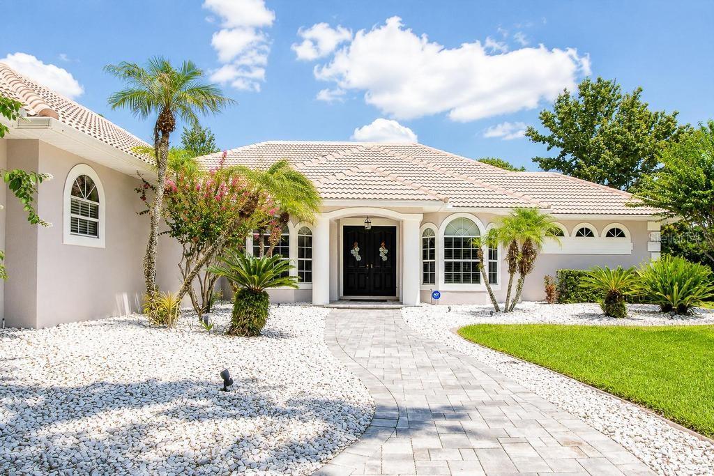 A single-story house with a tiled roof, white gravel landscaping, and a paved walkway — 9606 CAMBERLEY CIRCLE, ORLANDO, FL