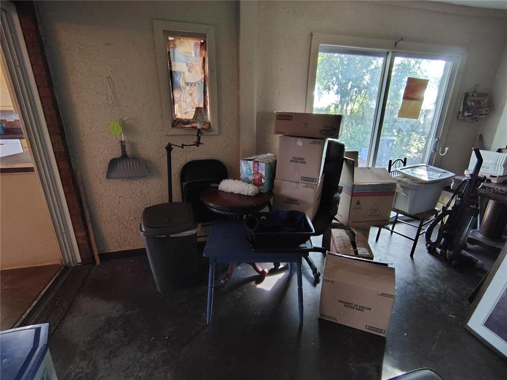 A cluttered room with a sliding glass door, a small window, and several cardboard boxes — 3537 E C 462, WILDWOOD, FL