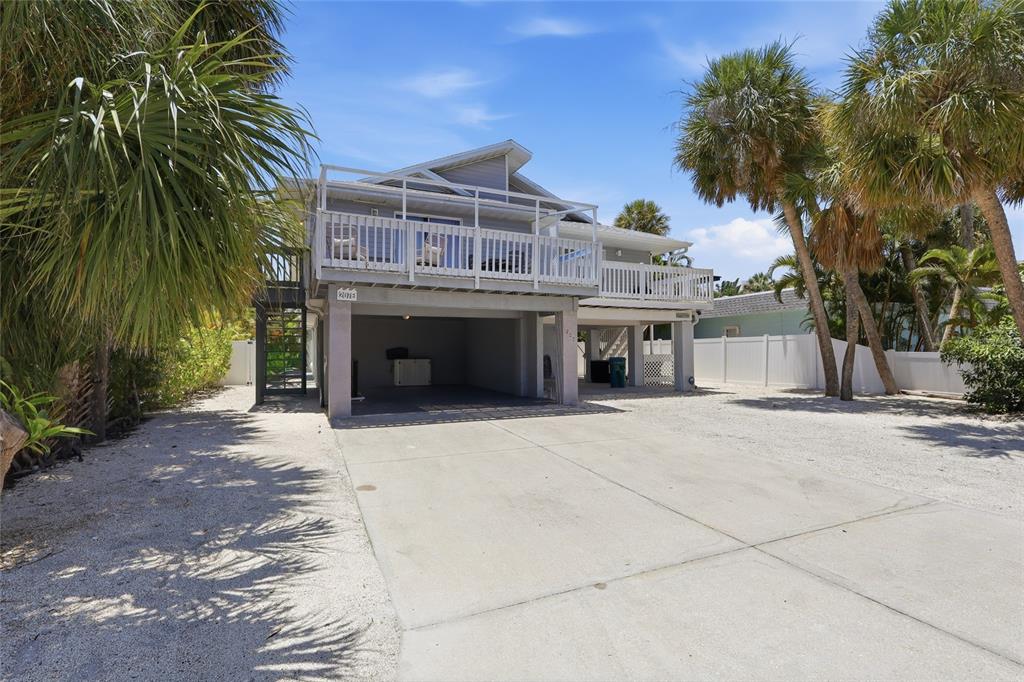 A backyard features a small rectangular swimming pool, artificial turf, patio furniture, and a two-story house — 207 71ST STREET UNIT E, HOLMES BEACH, FL