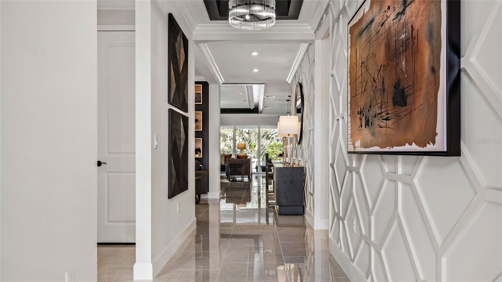 A hallway with tile floors, a geometric wall feature, and a large abstract painting — 545 HAMMOCK OAKS BOULEVARD, LADY LAKE, FL