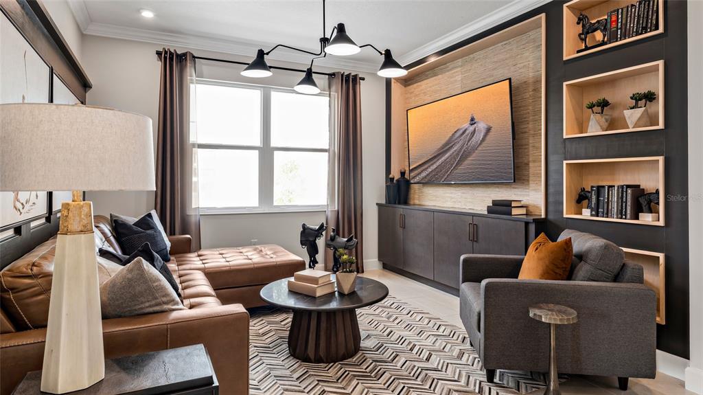 A living room features a leather sectional, a gray armchair, and a built-in media wall — 545 HAMMOCK OAKS BOULEVARD, LADY LAKE, FL