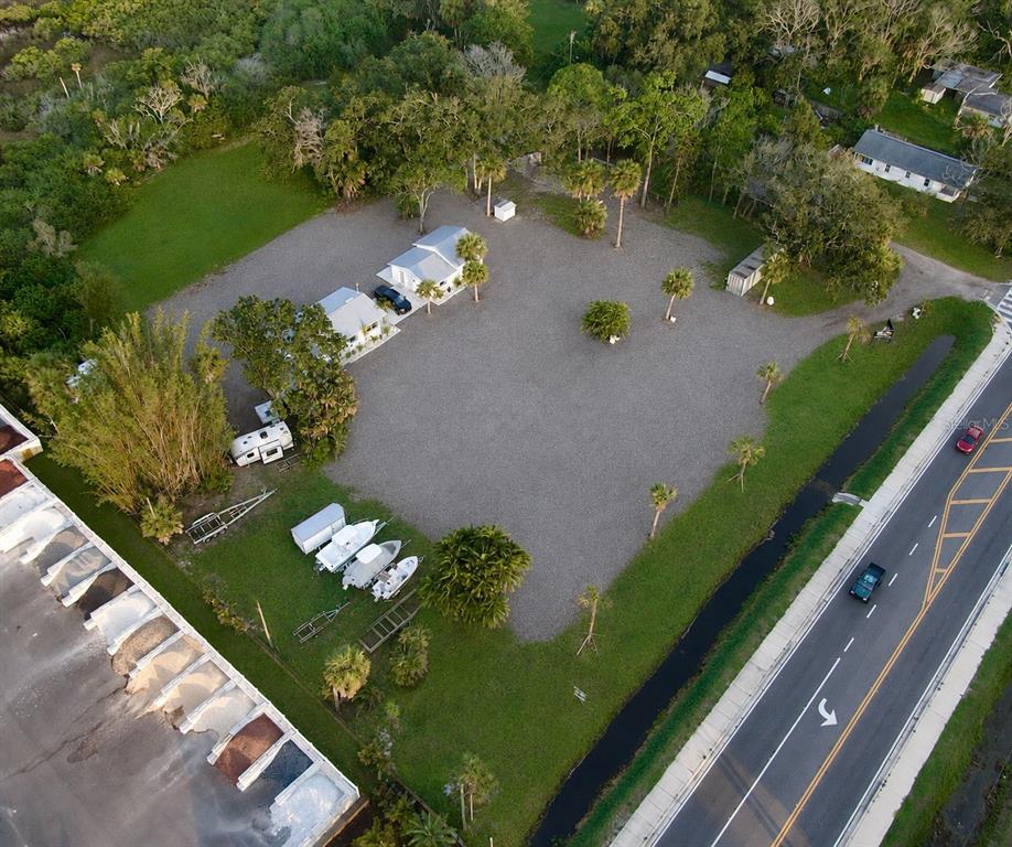 A white detached garage with a roll-up door sits on a gravel lot — 1322 N PINELLAS AVENUE, TARPON SPRINGS, FL