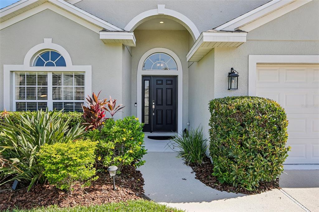 A single-story house with a beige stucco exterior, a two-car garage, and a front walkway — 4907 58TH TERRACE E, BRADENTON, FL