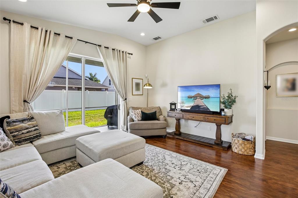 The exterior of a house features a black front door, arched windows, and landscaping — 4907 58TH TERRACE E, BRADENTON, FL