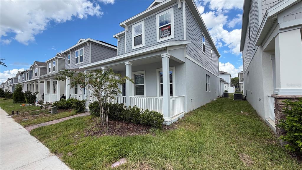 A two-story light blue house with a front porch and a small side yard — 4125 PINO STREET, APOPKA, FL