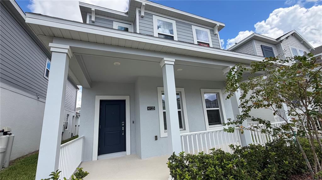A light gray two-story house features a covered front porch with white columns and railings — 4125 PINO STREET, APOPKA, FL