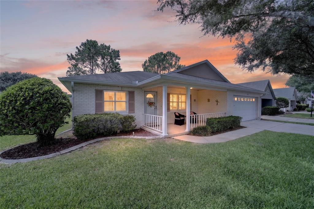 A single-story brick house with a front porch, attached garage, and a lawn — 8964 SW 95TH STREET UNIT A, OCALA, FL
