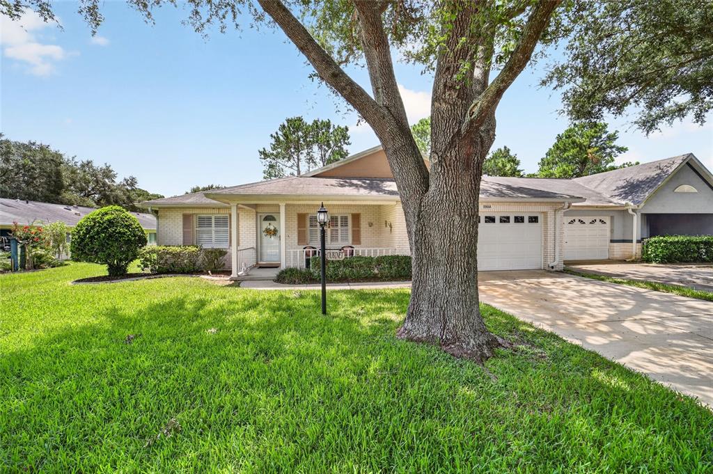 A living room with beige carpet, patterned sofas, a wooden entertainment center, and a dining area — 8964 SW 95TH STREET UNIT A, OCALA, FL