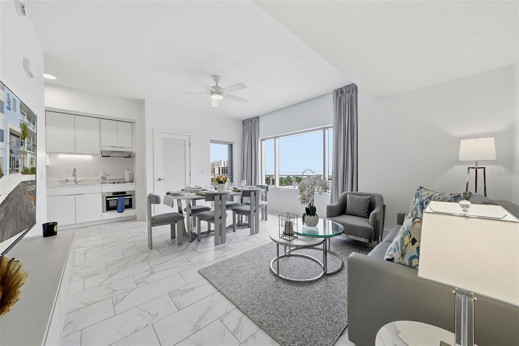 A modern open-concept living and dining area features white cabinetry, marble-look tile floors, and views — 411 E SHORE DRIVE UNIT 514, CLEARWATER BEACH, FL