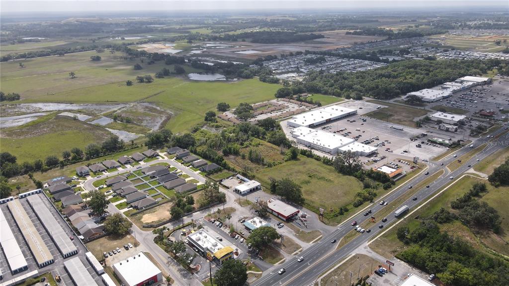 An aerial view shows a residential neighborhood, commercial buildings, and a highway — US HIGHWAY 301, DADE CITY, FL
