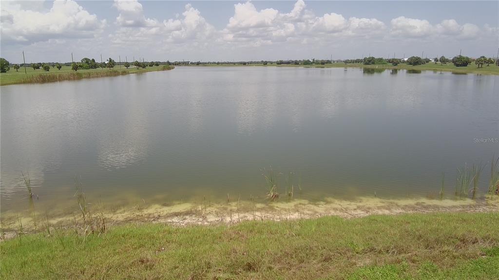 A view of a large pond with grassy banks under a cloudy sky — 45 SUNFLOWER DRIVE, PLACIDA, FL