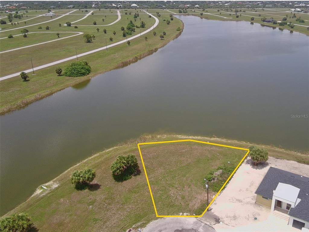 An aerial view shows a vacant, trapezoidal waterfront lot outlined in yellow next to a house — 45 SUNFLOWER DRIVE, PLACIDA, FL