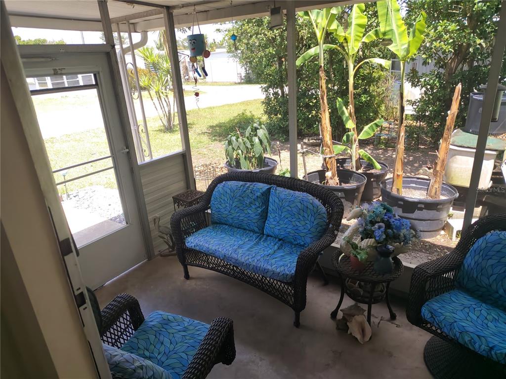 A living room features a television, a fish tank, a coffee table, and a sofa — 37748 MARKLAND AVENUE, ZEPHYRHILLS, FL