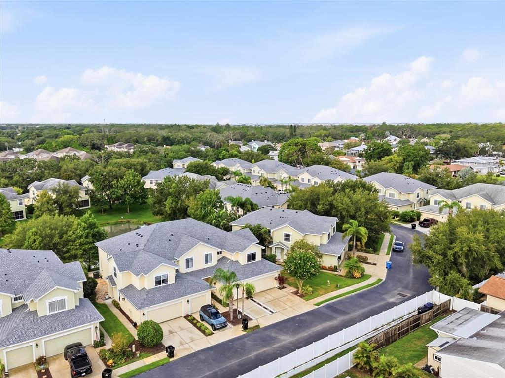 An aerial view of a suburban neighborhood featuring multi-family residential buildings and paved streets — 368 HARBOR RIDGE DRIVE, PALM HARBOR, FL