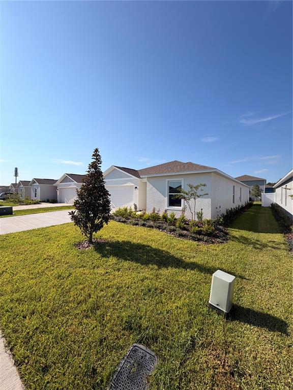 A single-story suburban house features a light-colored exterior, a garage, and a manicured lawn — 1912 PINE MEADOWS GOLFCOURSE RD, EUSTIS, FL