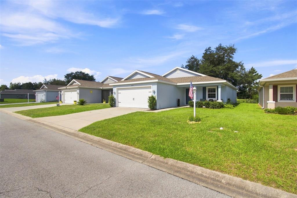 A row of single-story suburban houses with light blue siding and attached garages — 10535 S DREW BRYANT CIRCLE, FLORAL CITY, FL