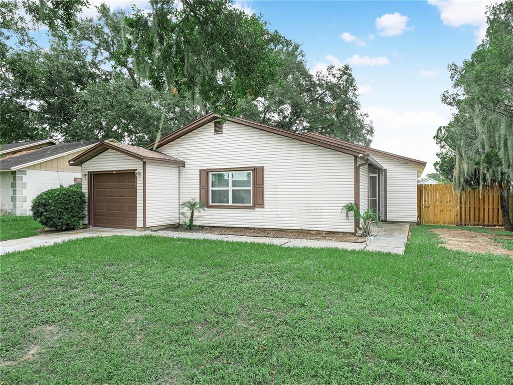 A single-story house with white siding, a brown garage door, and a front lawn — 1665 SAILPOINT DRIVE, BARTOW, FL