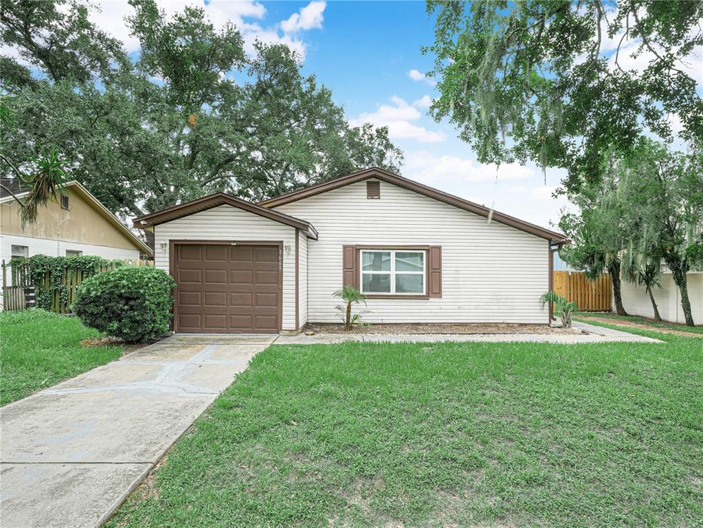 A single-story house with white siding, a brown garage door, and a front lawn — 1665 SAILPOINT DRIVE, BARTOW, FL