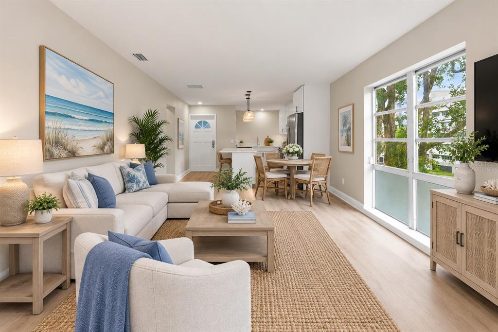 A two-story white apartment building features an exterior staircase and a paved parking lot — 2950 W BAY DRIVE UNIT B1, BELLEAIR BLUFFS, FL