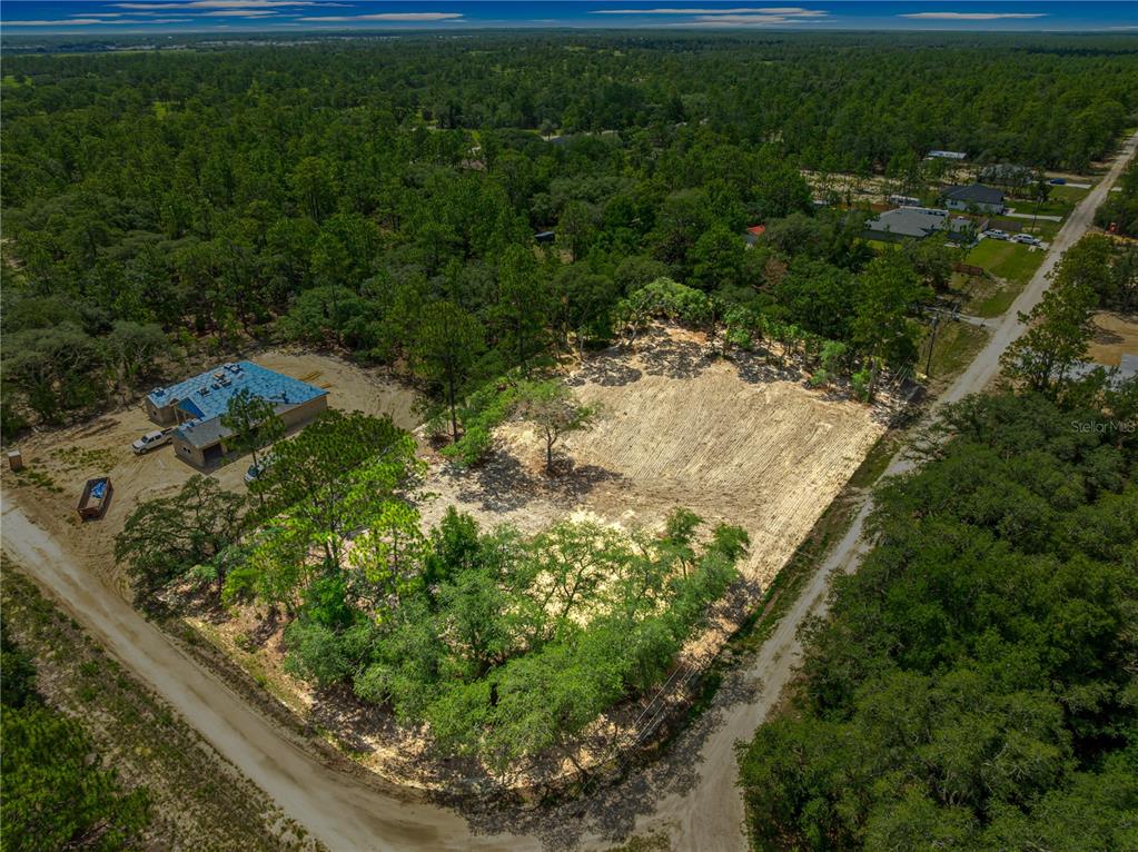 An aerial view shows a cleared residential lot with a house under construction nearby — 8141 SW 122 AVENUE, DUNNELLON, FL