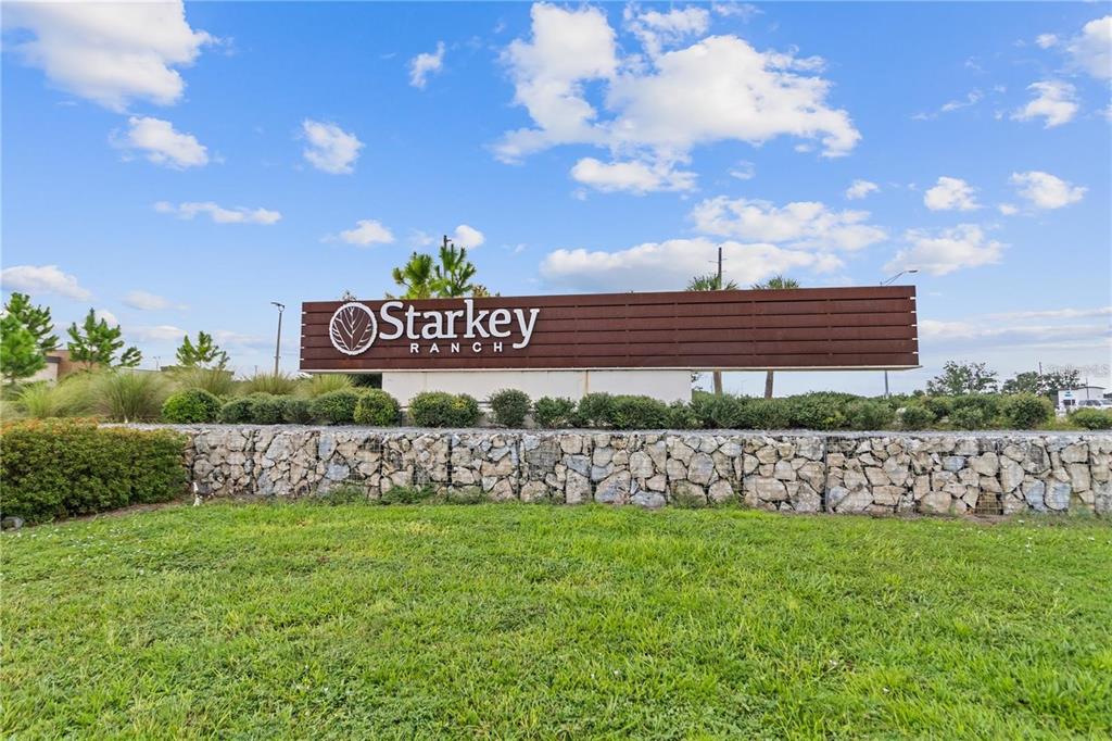 A large brown Starkey Ranch community sign sits above a stone retaining wall and lawn — 2967 BARBOUR TRAIL, ODESSA, FL