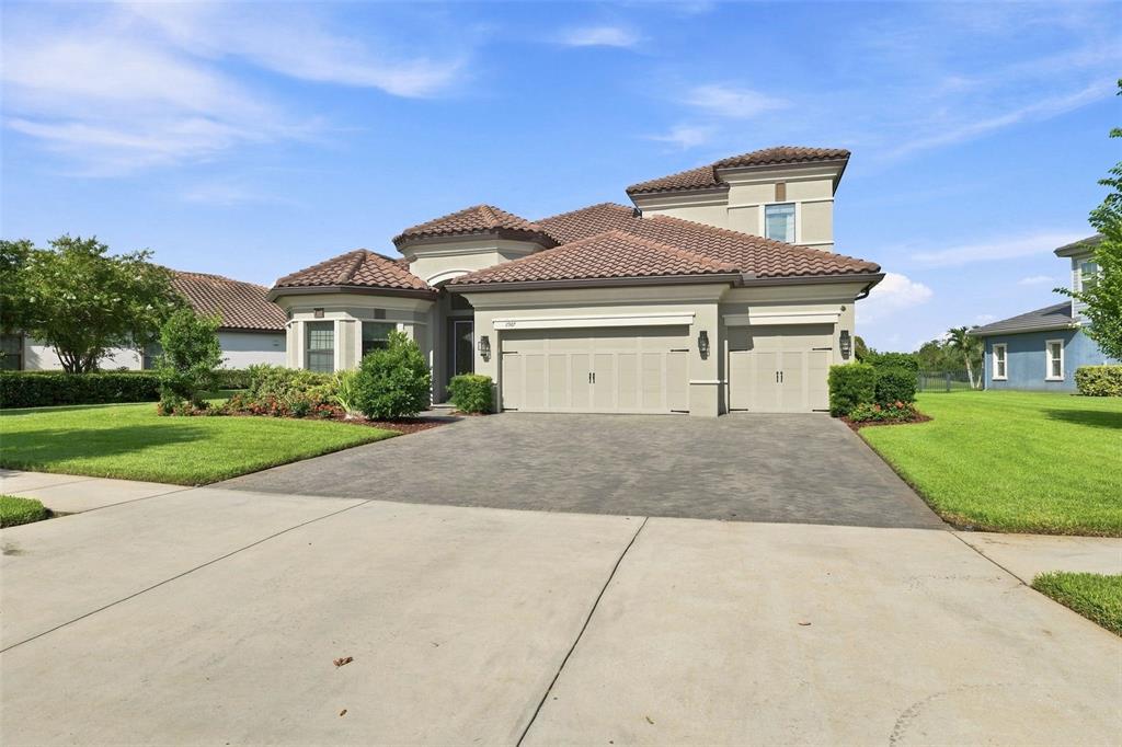 A tan single-story house with a tile roof and a three-car garage — 2967 BARBOUR TRAIL, ODESSA, FL